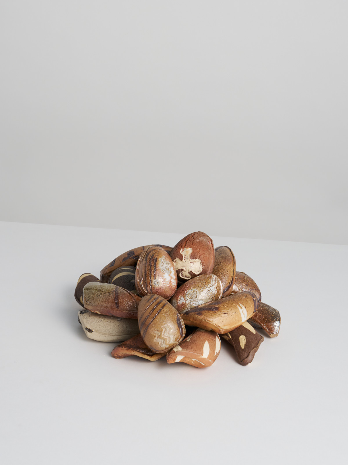 A pile of press-moulded rattles in the shape of whale teeth and bird eggs