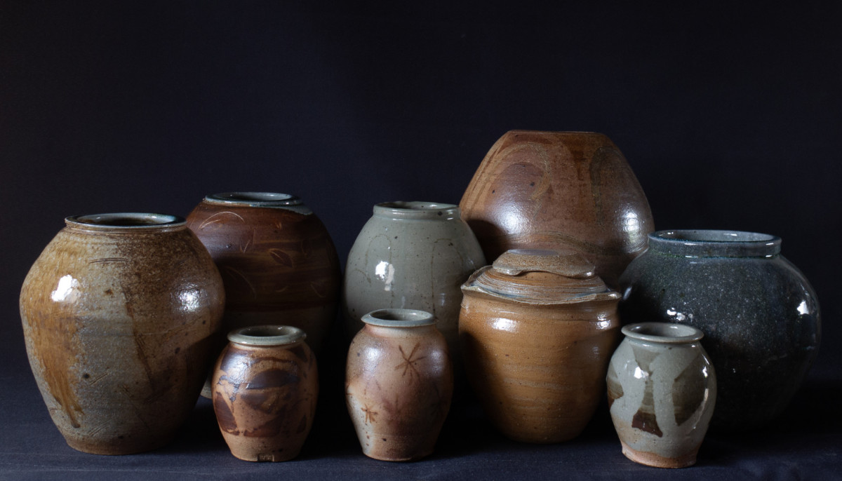 A selection of stoneware jars on a dark background