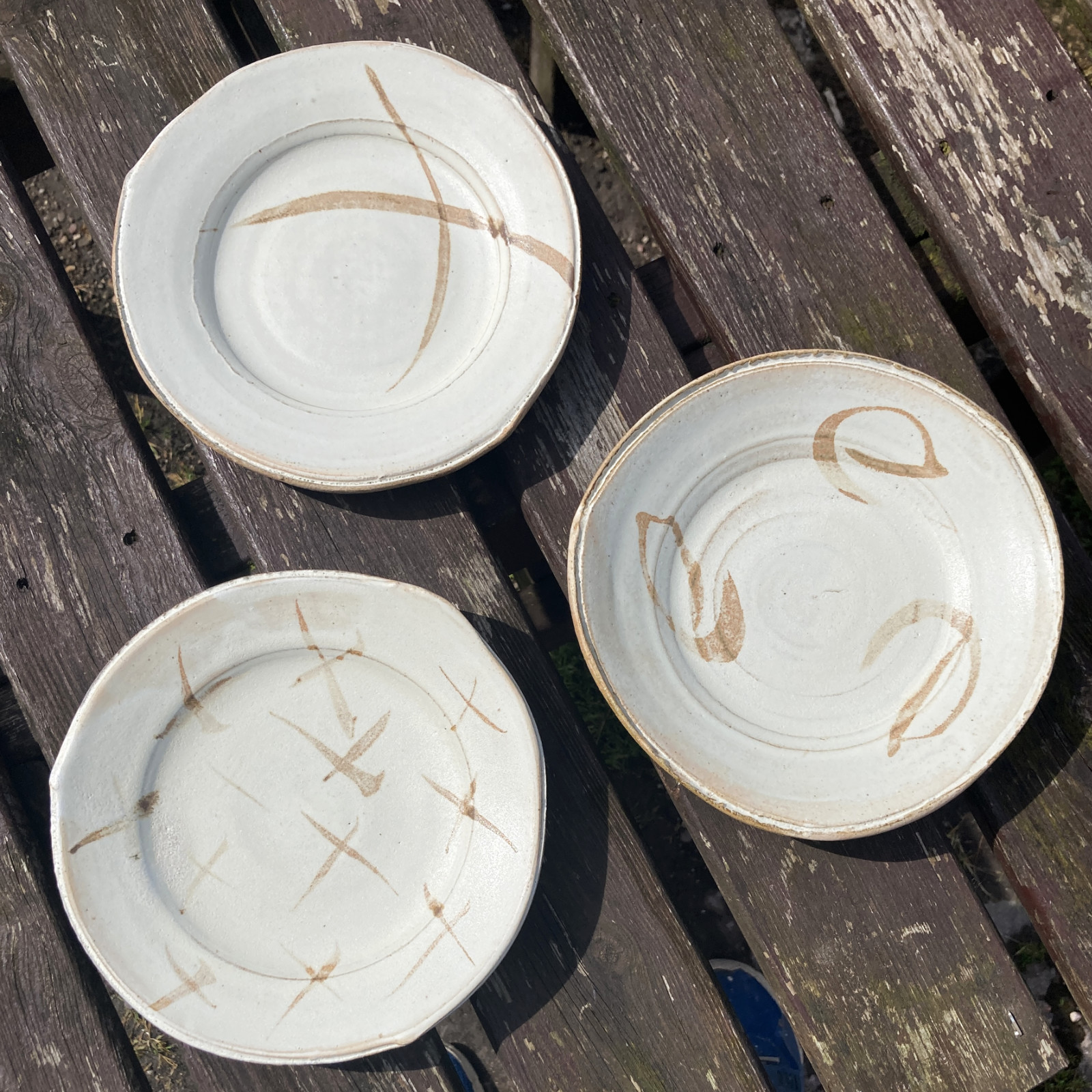 Three white plates with iron-wash decoration