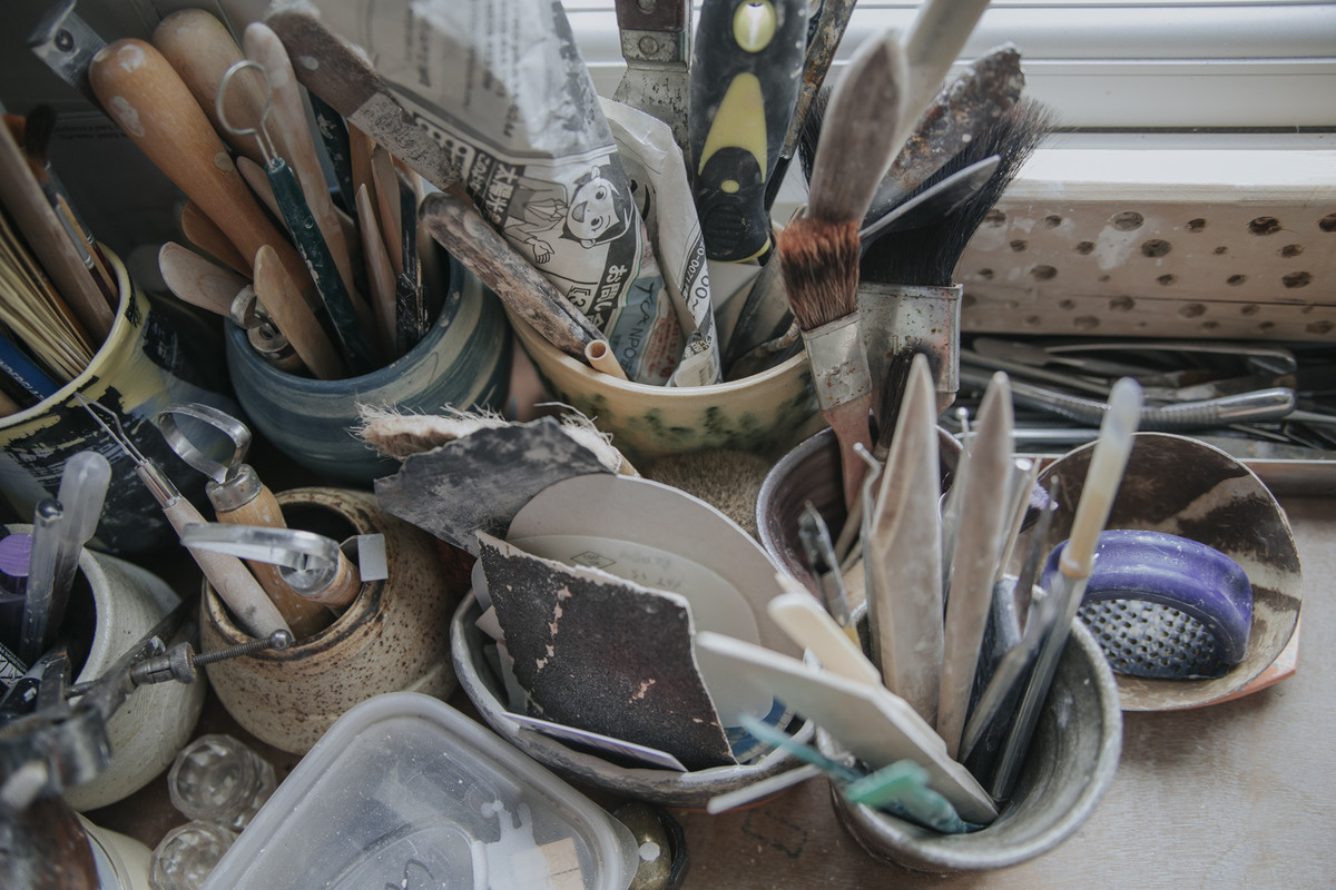 A messy collection of tools in studio storage containers