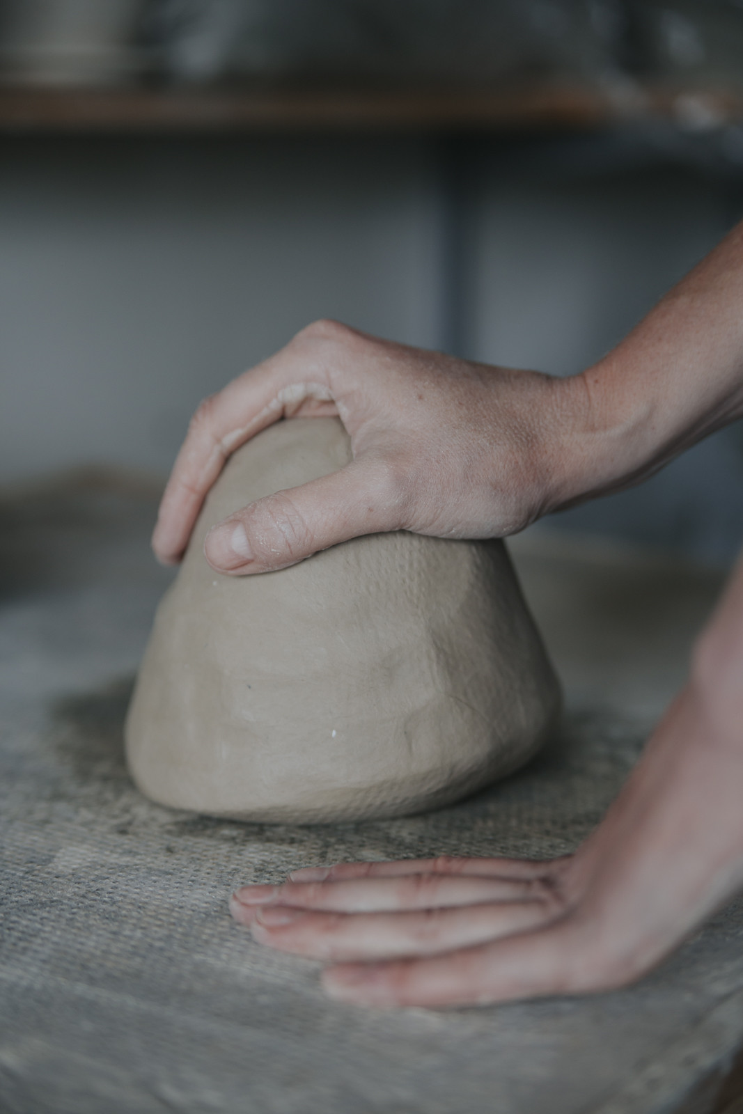 Potter's hands on a kneaded piece of clay