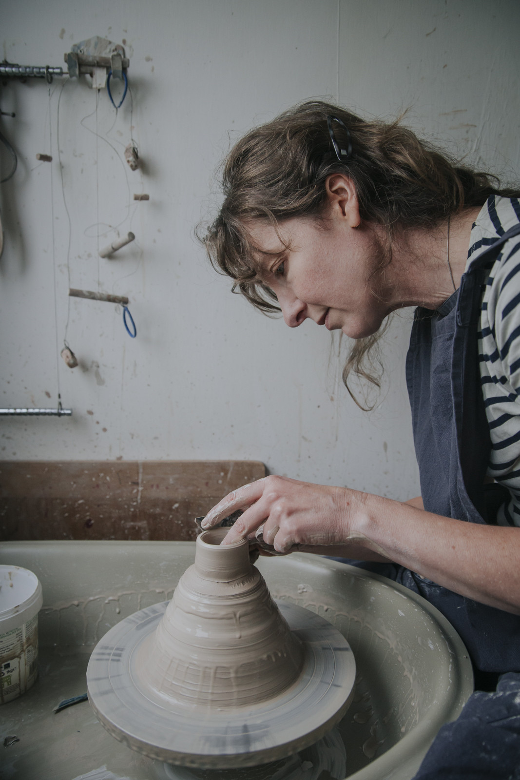 Rowena Hamilton throwing a tiny cup on the potters' wheel 'off the hump'